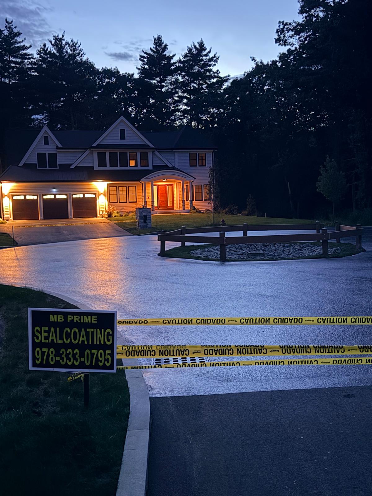 Completed sealcoating on a large circular driveway at dusk
