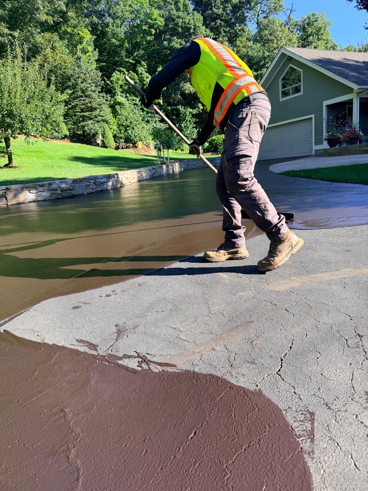 MB Prime crew member applying sealcoat by squeegee